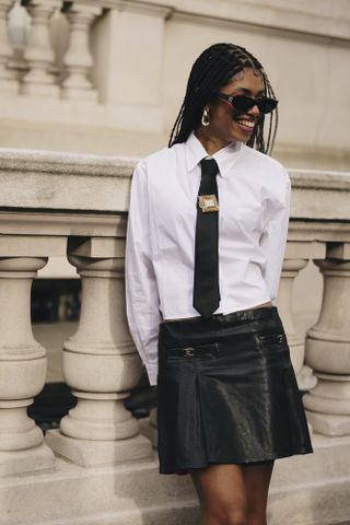 A woman at new york fashion week wearing a brooch in a street style outfit