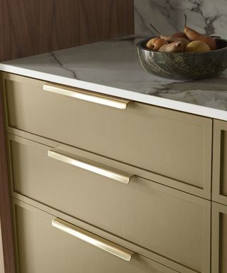 An earthy green and gold kitchen cabinet