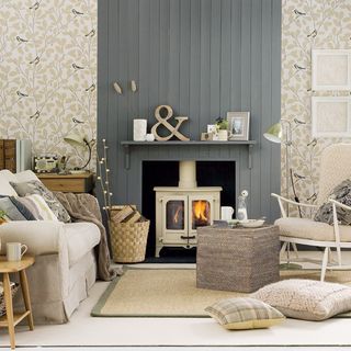 Cream and grey living room with wall panelling on the chimney breast and a shelf mounted above a cream wood burner