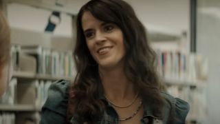 Mary Holland smiling in a library in Nightbitch