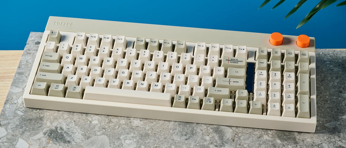 The Lofree Block keyboard on a stone surface with a blue wall in the background.