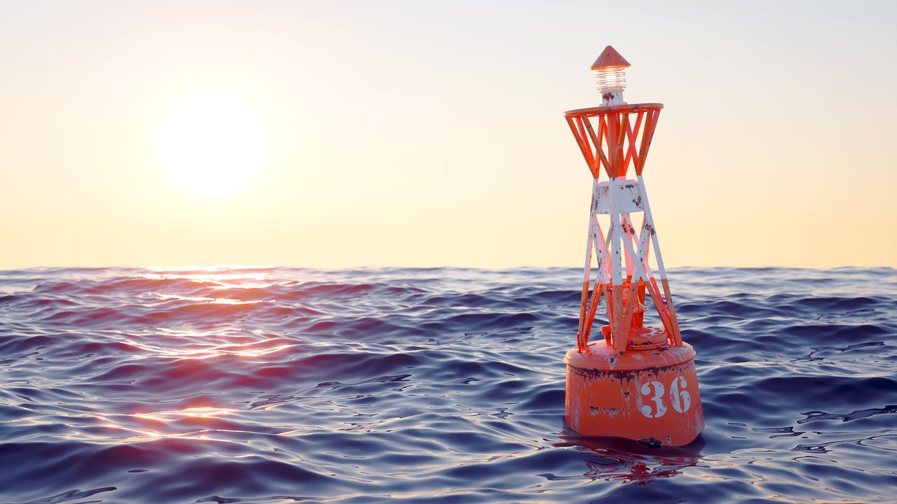 Orange buoy in the open sea on the sunset background