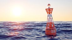 Orange buoy in the open sea on the sunset background