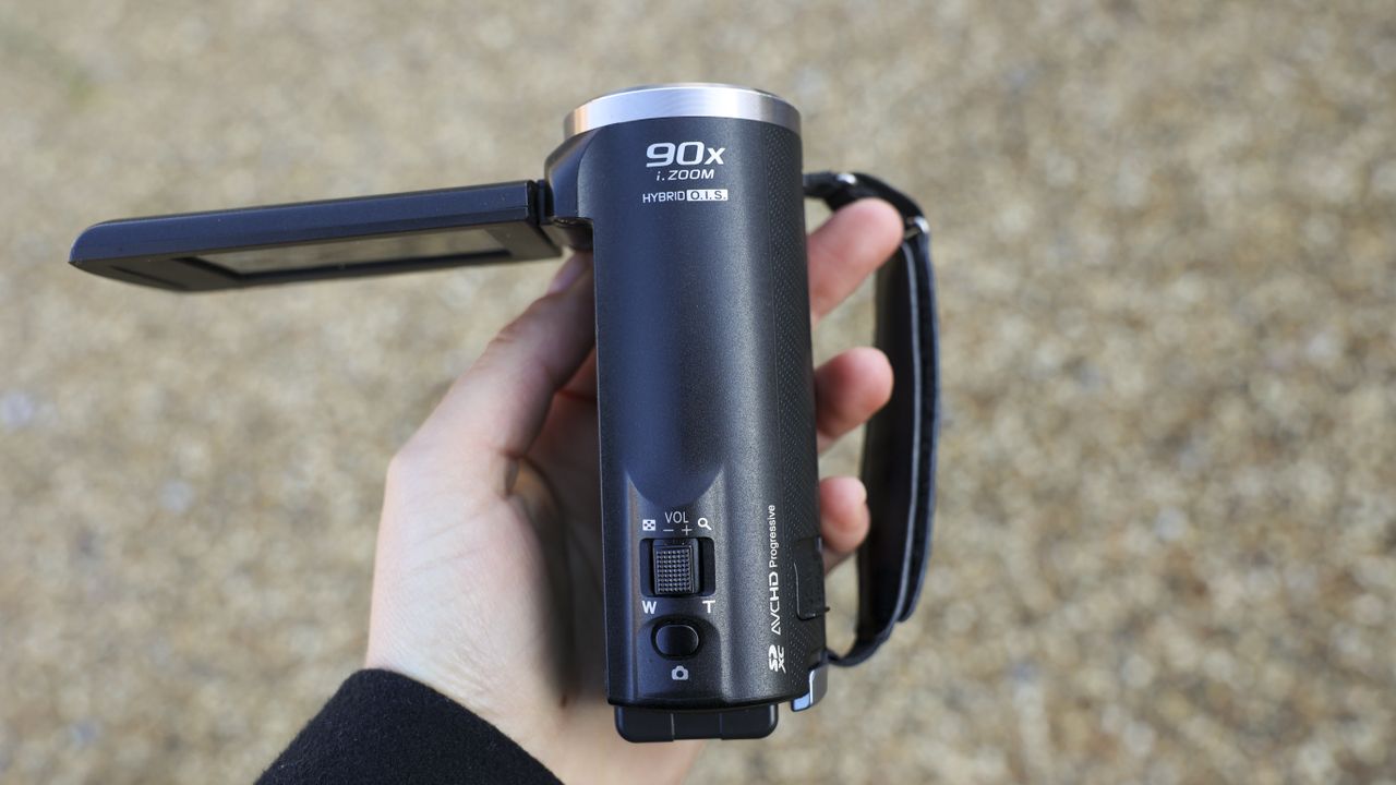 A top view of the Panasonic V180 camcorder being held by a young woman