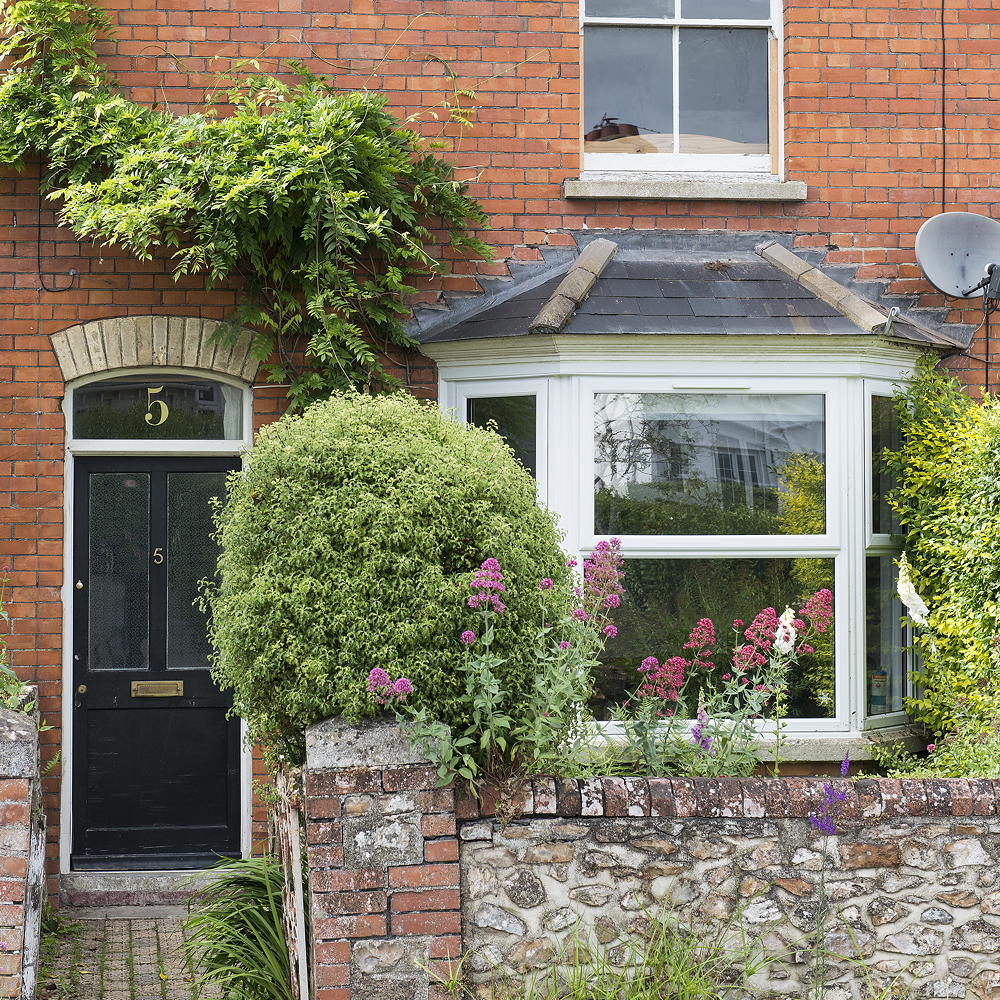 home with brick wall and black front door