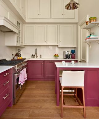 Victorian kitchen with cherry red lower cabinets and white uppers, small breakfast bar and coffee maker visible on back counter