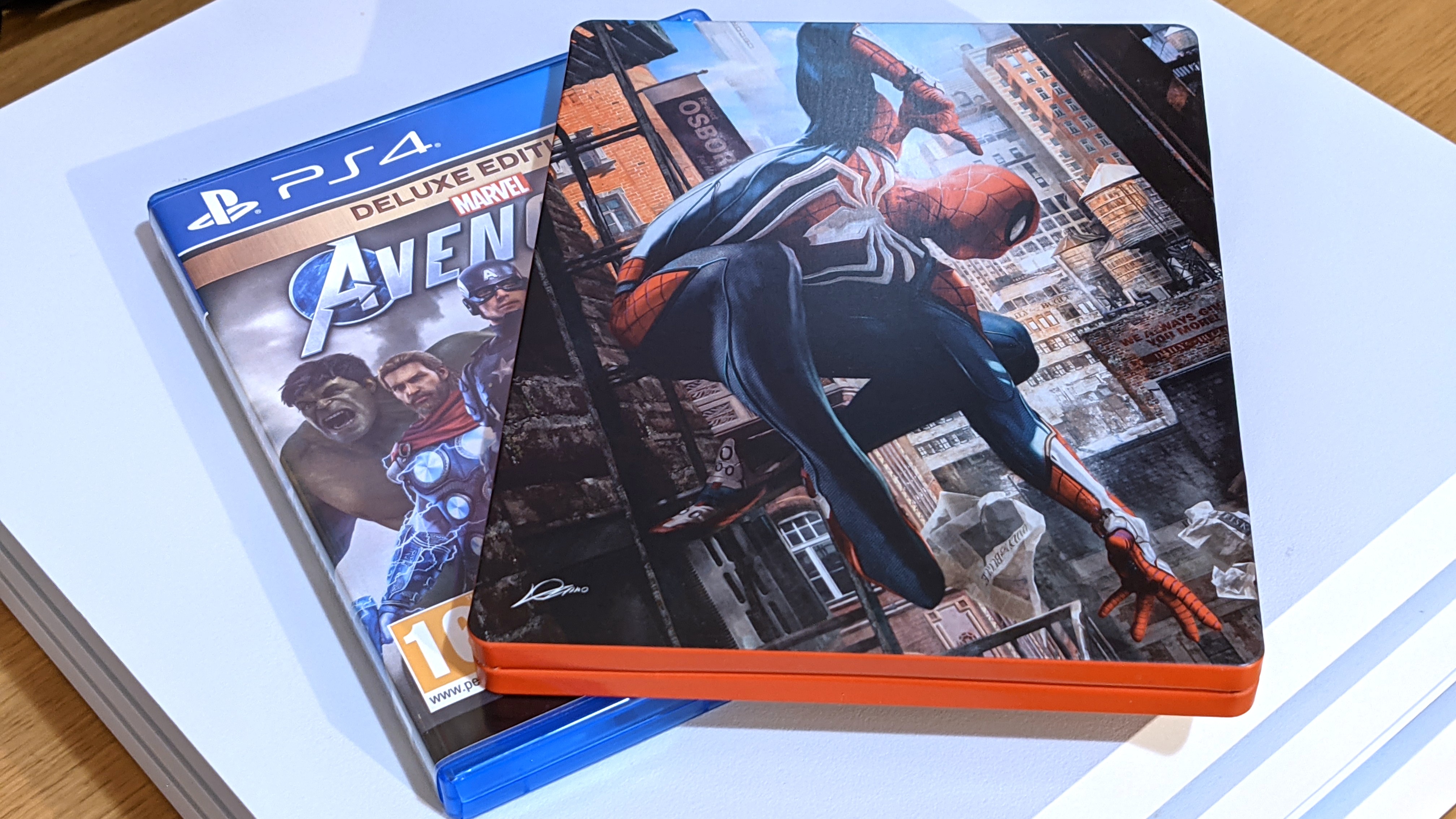 A photo of Marvel's Avengers and Marvel's Spider-Man PS4 game cases on top of a white PS4 Pro.