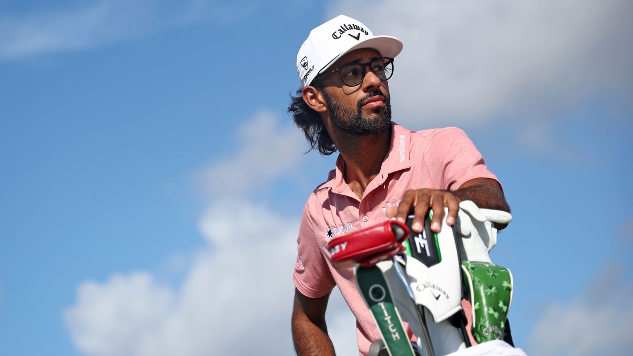 Akshay Bhatia standing with his hand on his driver in his golf bag