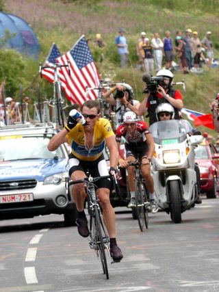 Lance Armstrong takes a drink after catching and passing Ivan Basso on the climb of Alpe d'Huez