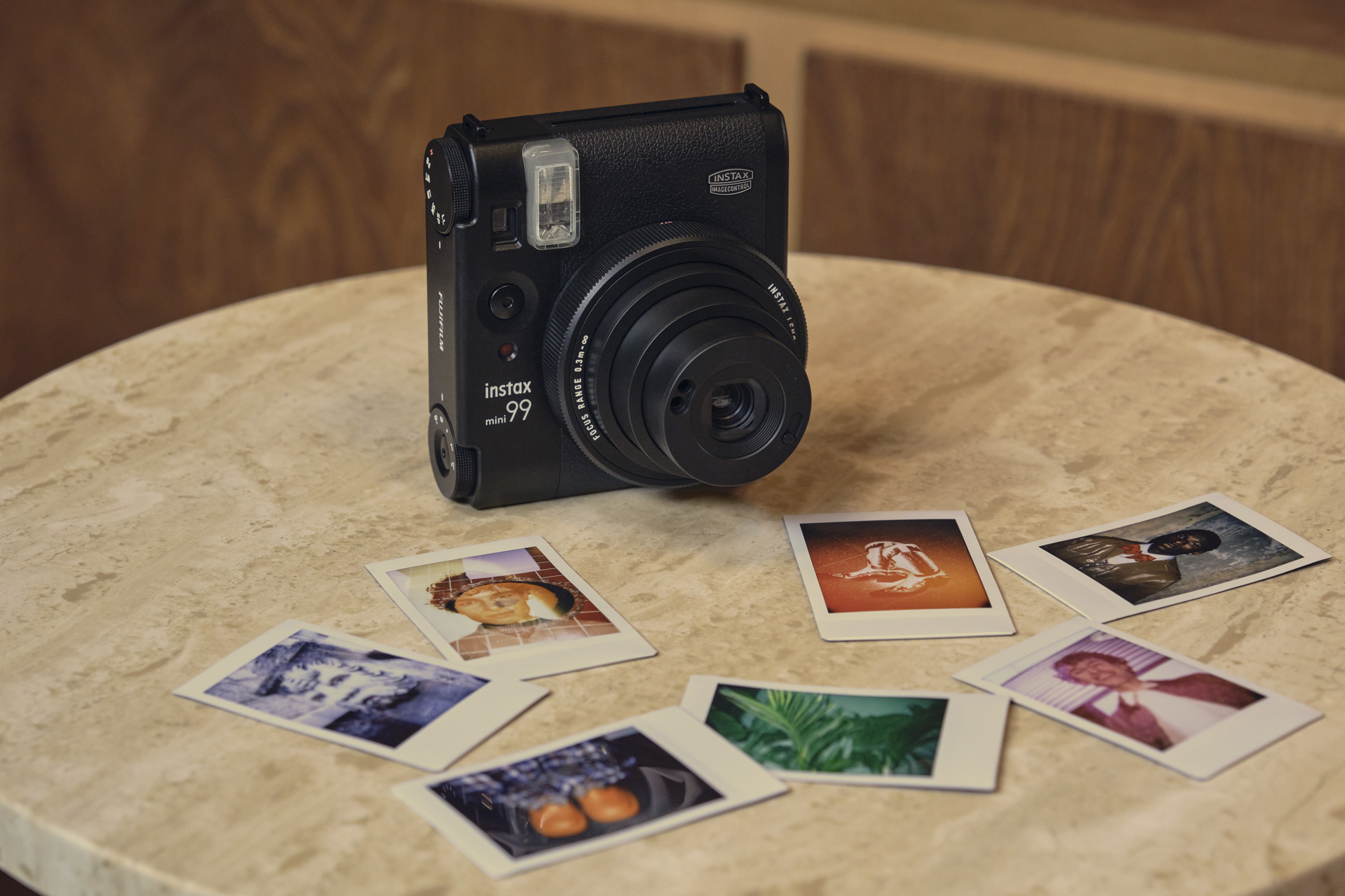 Fujifilm Instax Mini 99 on a marble table with mini prints