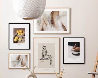 Wall gallery display of neutral framed abstract and still-life inspirations