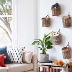 white living room with sofa and baskets hanging on the wall