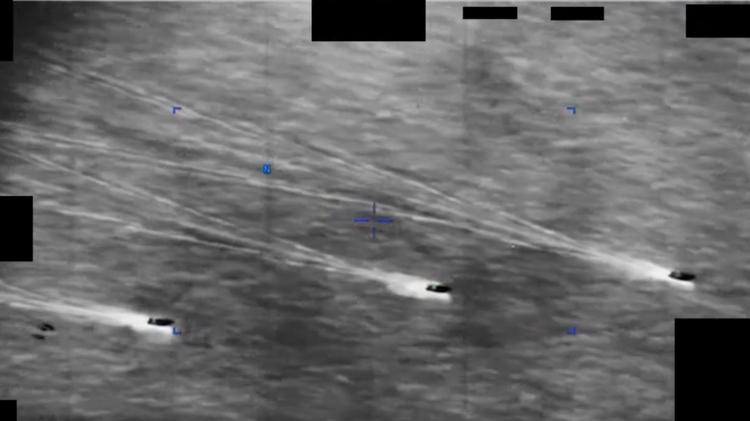 Three ships on a gray sea spot a hovering object in this DoD video