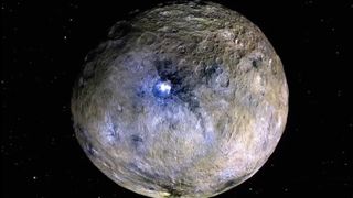 An image of Ceres in space with a glowing energy source at its center