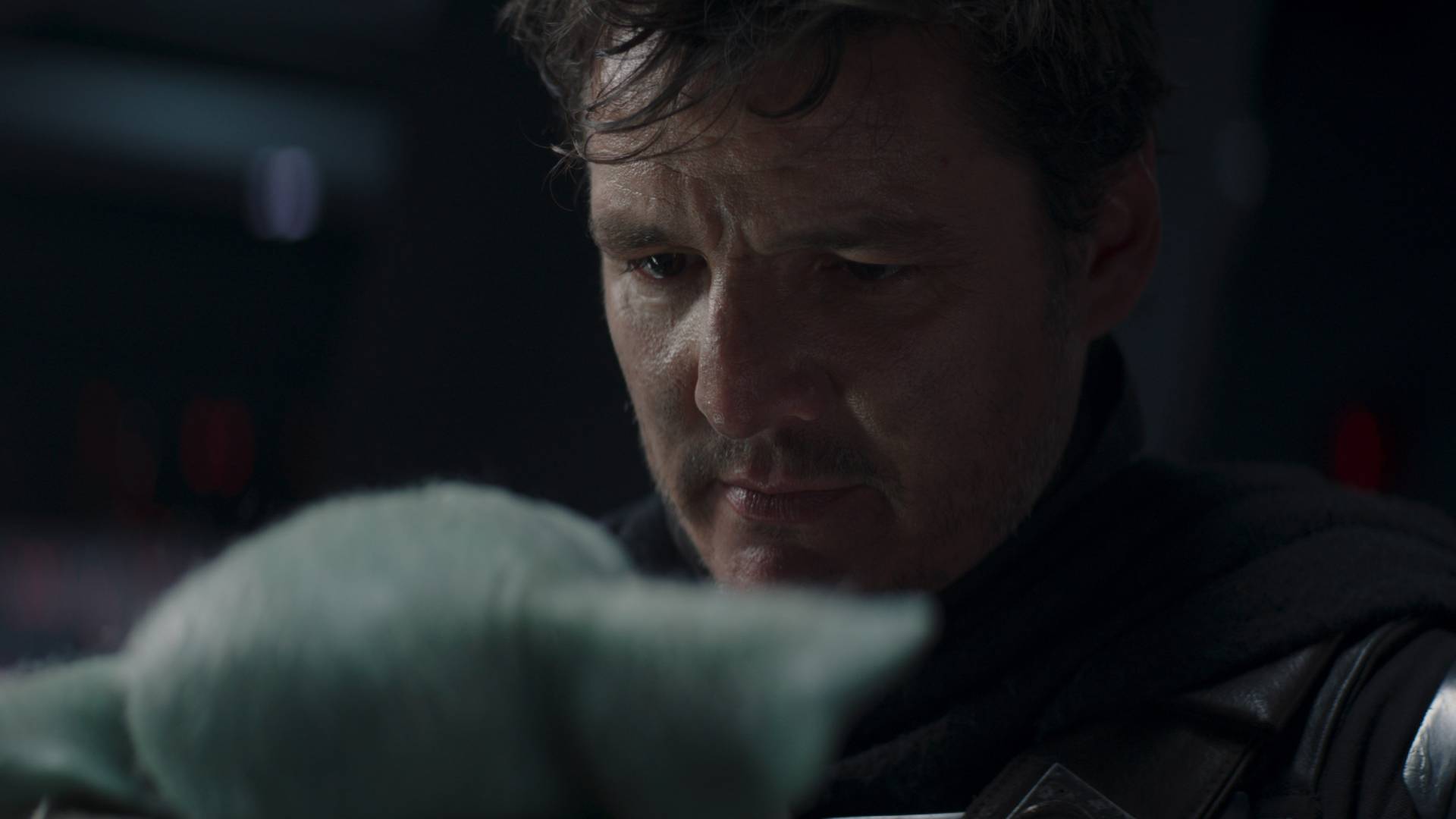 Pedro Pascal's Din Djarin unmasked looking at Grogu in The Mandalorian