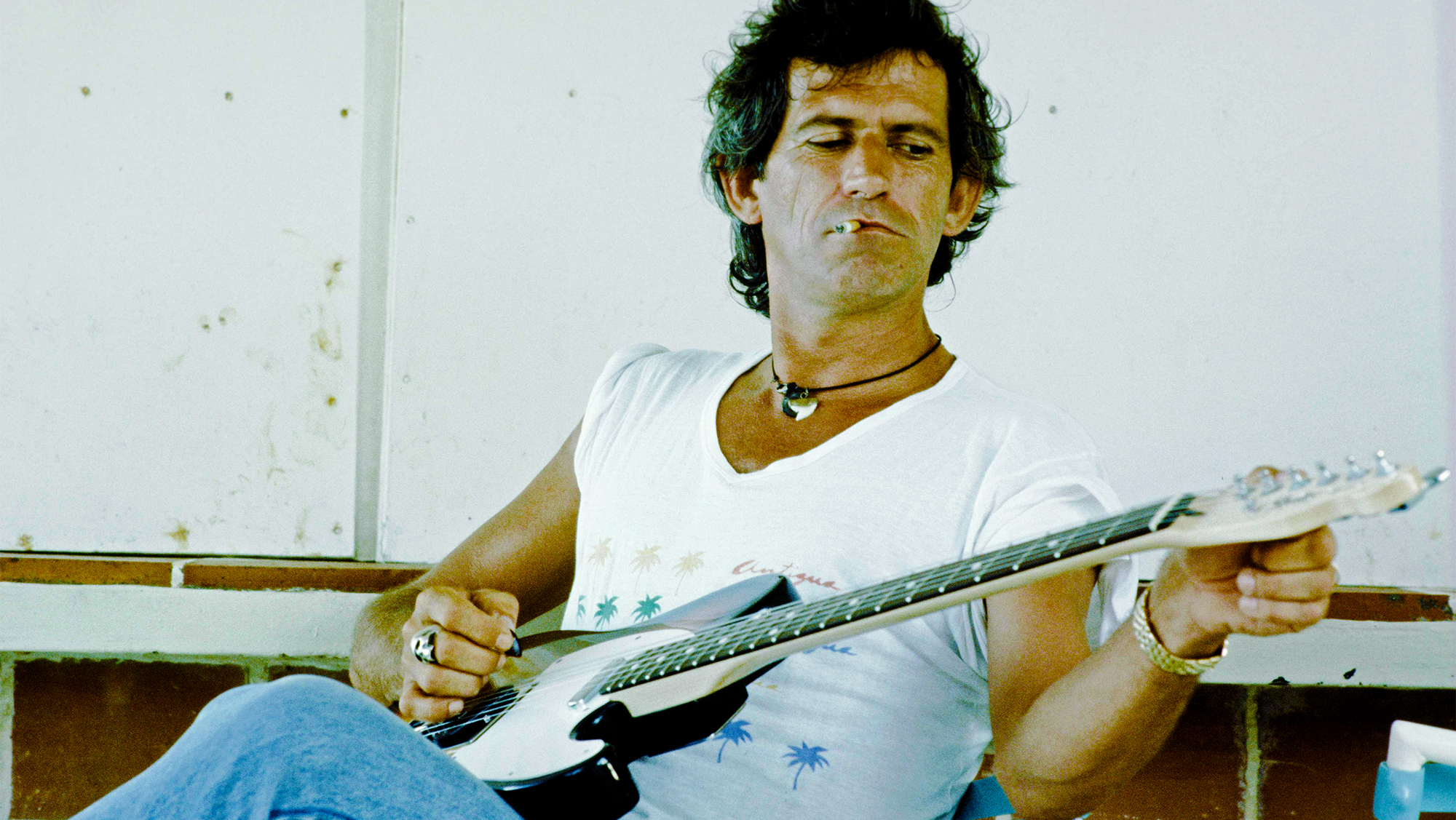 Rolling Stones Keith Richards getting interviewed on overseas beach, unknown, 1986.