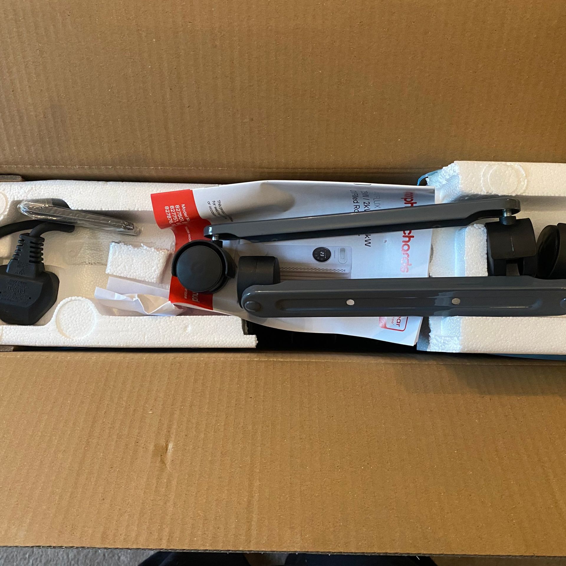 Open packaging of the Morphy Richards HeatFlux 2.5kW Digital Oil-filled Radiator showing the accessories in polystyrene packaging