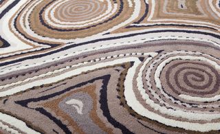 Upclose image of a rug with spiral patterns in shades of brown