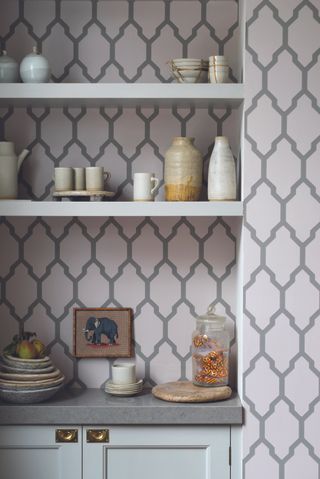 Wallpaper in a kitchen alcove with mint green shelves by Farrow & Ball