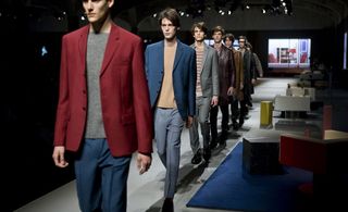 The furnishings complemented the sleek collection of colourful blazers, butter-soft leather and cropped trousers that made up Prada's A/W 2013 menswear offering. The models weaved their way through the set, acting as characters in AMO's domestic environment