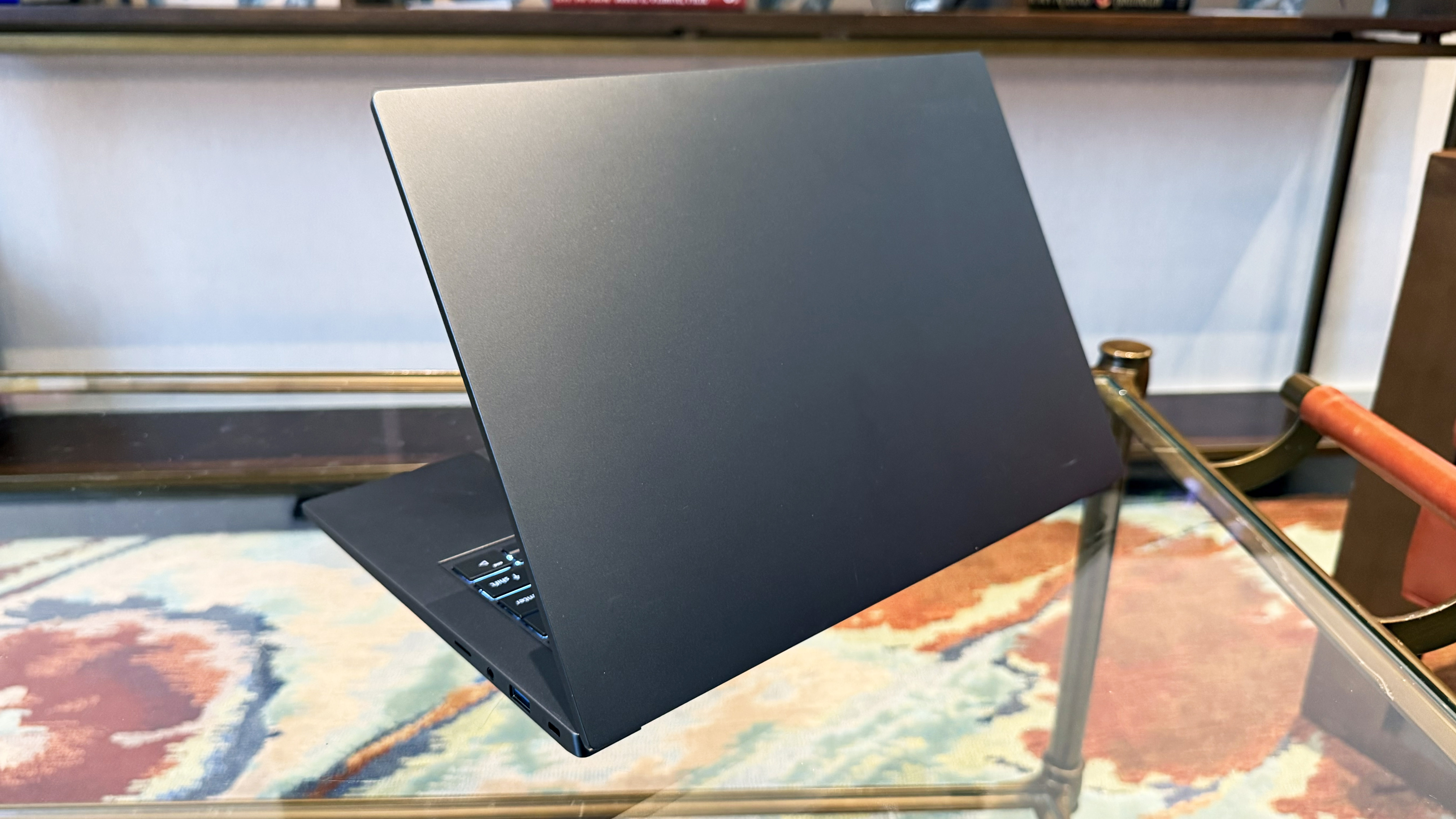 Acer Swift X 14 AI creator laptop facing away on a glass table.