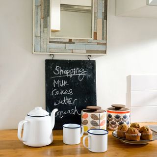 kitchen accessories with blackboard and tea pot with tea cups and cup cakes