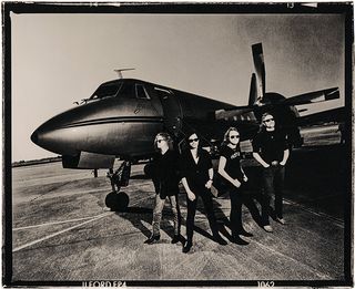 Metallica standing by a private jet