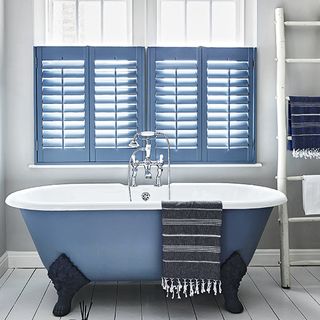 bathroom with bathtub and white window