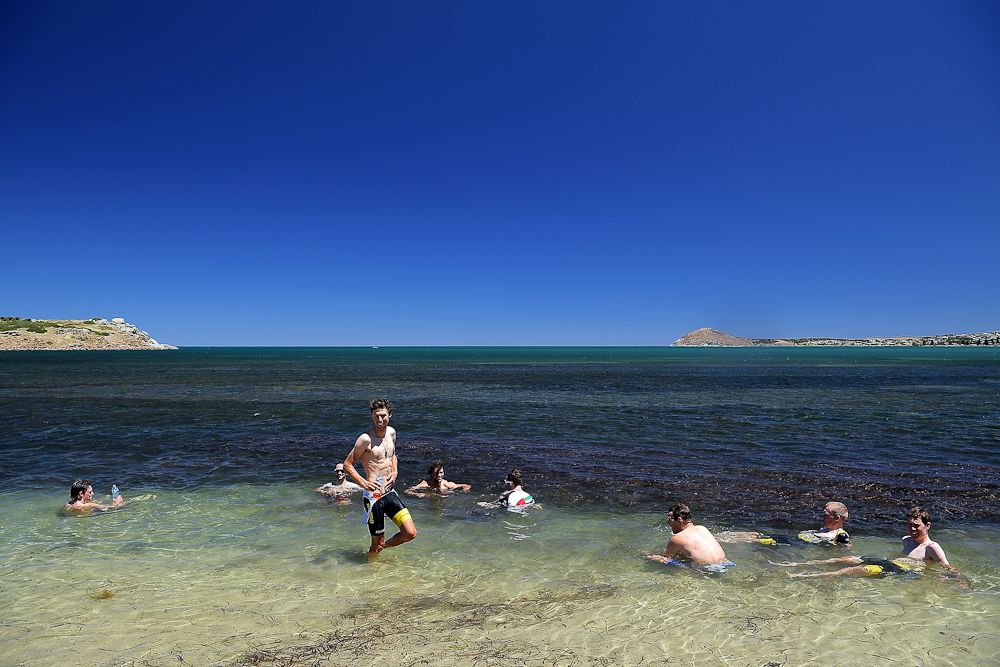 Riders cool off in the ocean after stage three of the 2018 Tour Down Under