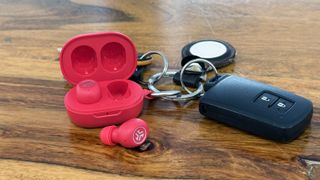 JLab JBuds Mini ANC attached to a set of keys, with the case open and one earbud outside the case