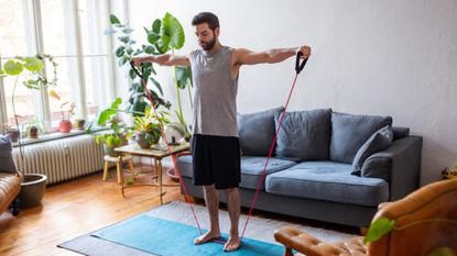 Man doing resistance band workout in living room