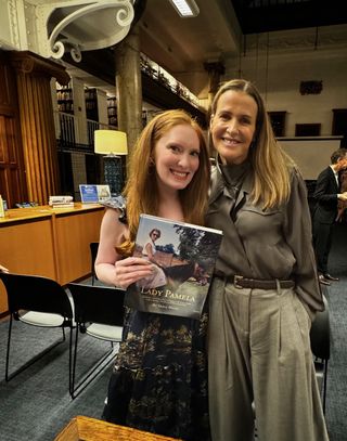 Kristin Contino holding the book Lady Pamela standing with India Hicks