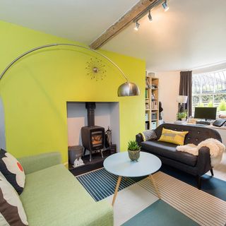 living room with yellow wall couch with cushions fireplace and lamp