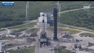 SpaceX's black and white Crew-9 Falcon 9 rocket atop its launch pad as astronauts arrive in black cars below on Sept. 28, 2024.