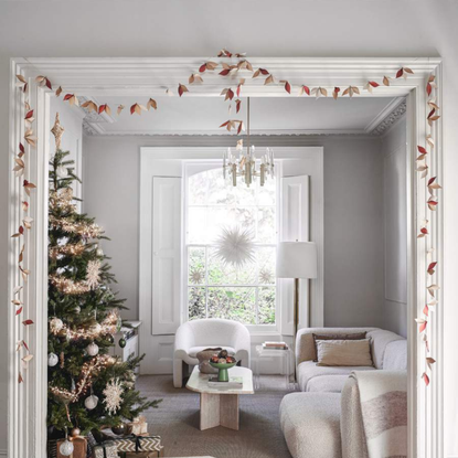 Christmas tree with rose gold decorations in white and cream living room