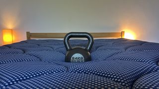 Assessing the comfort and support of the DreamCloud Luxe Memory Foam mattress by measuring how far a weight sinks in the middle of the bed.