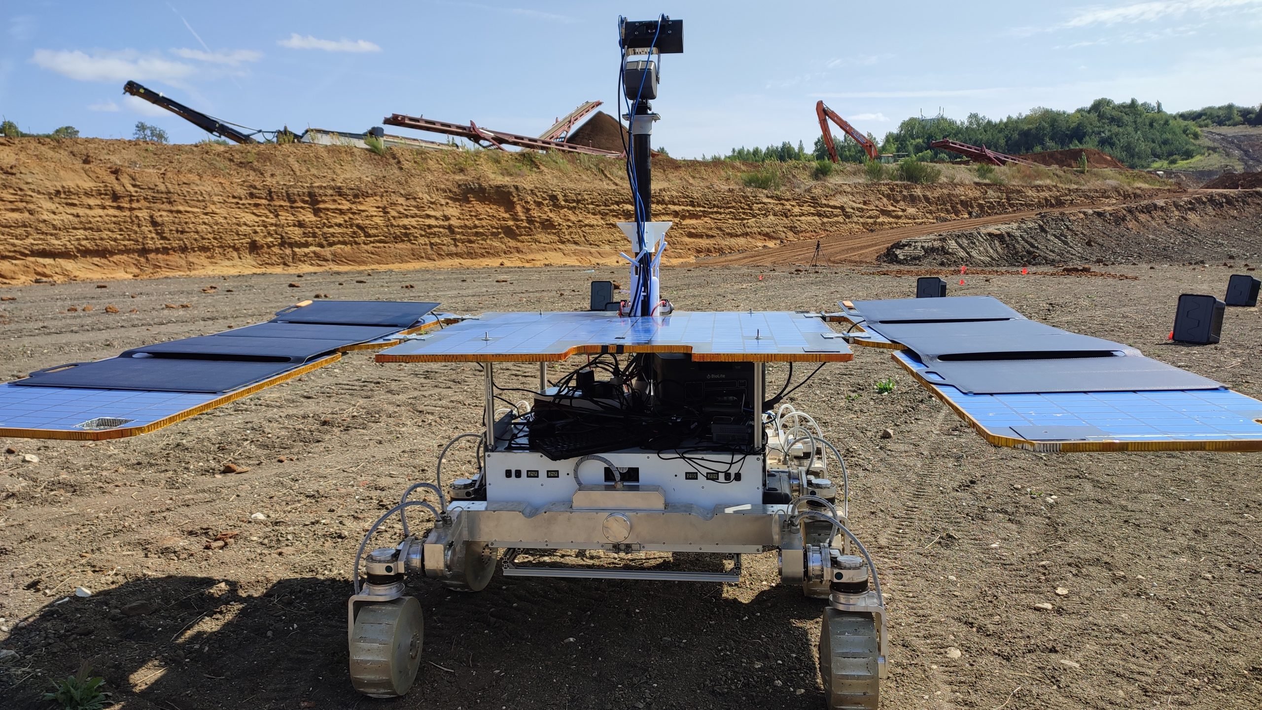 un rover de cuatro ruedas conduce sobre la tierra roja en un sitio de construcción