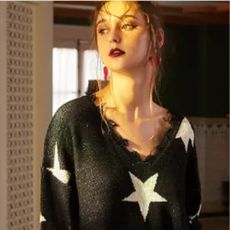 Woman wearing a black oversized jumper with white stars