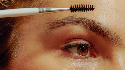 A close up of a woman using a spoolie on her eyebrow - how long does it take for eyebrows to grow back