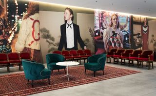 Indoor seating area with wall length posters of Gucci models