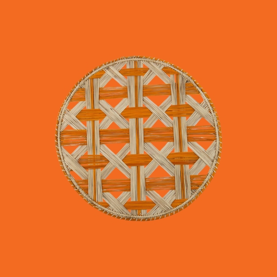 A rattan placemat in natural and orange against an orange background.