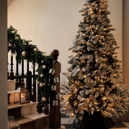 10ft artificial treen in a hallway. It has soft gold fairy lights.