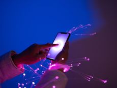 Close-up of holding smartphone, arms wrapped with fiber optics