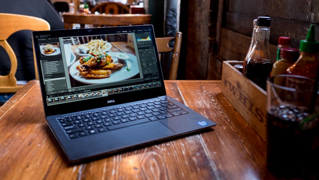 Dell laptop on a wooden table in a restaurant