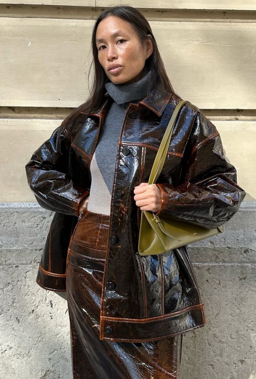 @vikilefevre wears a patent leather jacket, skirt and bag