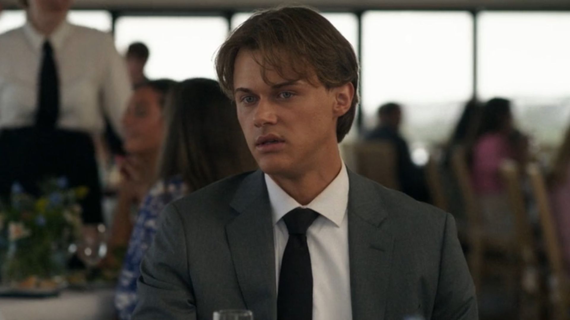 Conrad looks at something offscreen in disgust