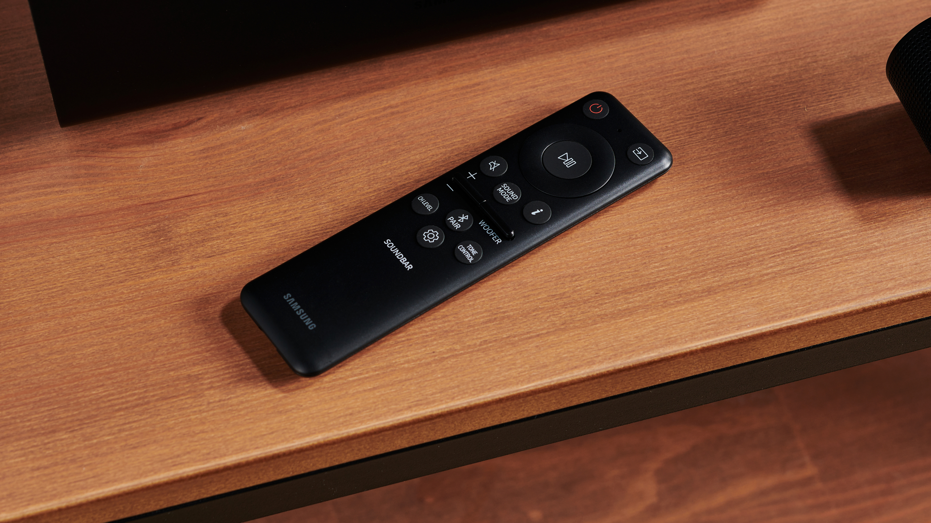 Samsung HW-S800B remote on TV unit with TV behind