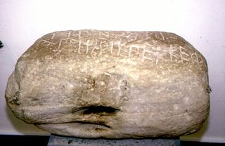 A large rock with ancient greek writing on it