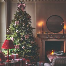 A living room decorated for Christmas with a Christmas tree adorned with bow decorations