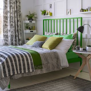 white bedroom with green bed and white flooring
